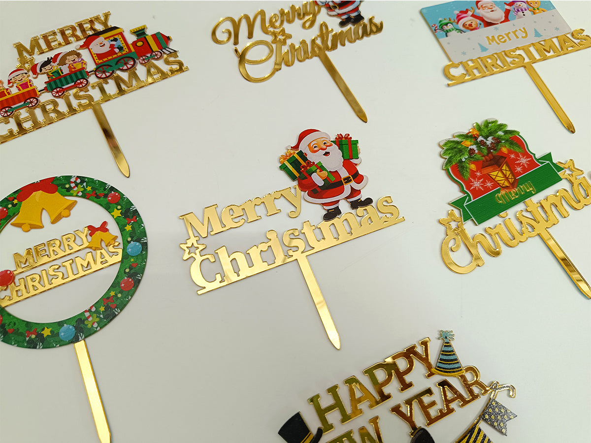Christmas-themed cake toppers with 'Merry Christmas' and 'Happy New Year' on sticks.